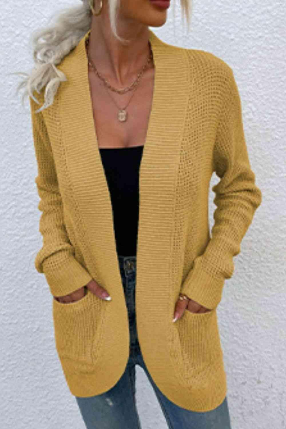 a woman wearing a mustard colored cardigan sweater