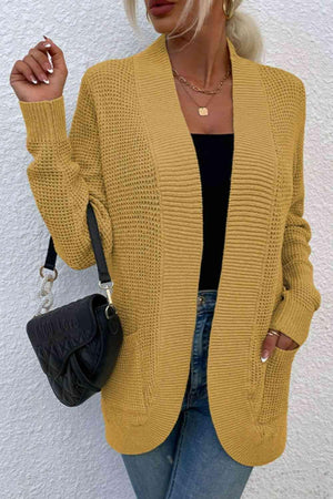 a woman wearing a yellow cardigan sweater and jeans
