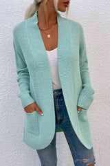 a woman wearing a green cardigan sweater and ripped jeans