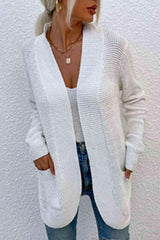 a woman wearing a white cardigan sweater and jeans