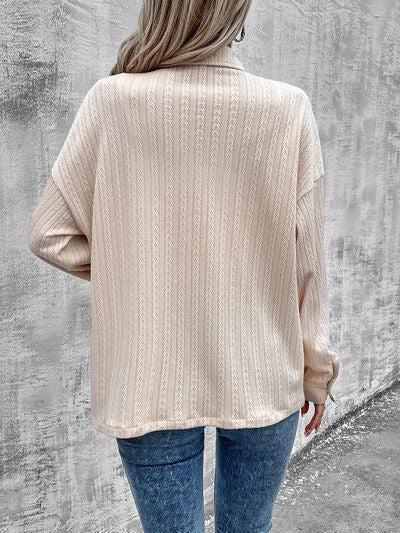 a woman wearing a beige sweater and jeans