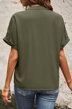 a woman wearing a green shirt and jeans