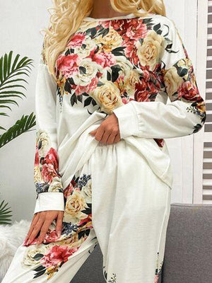 a woman sitting on a couch wearing a floral print top and pants
