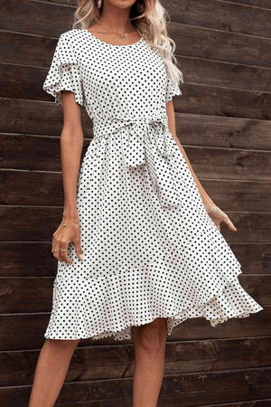 a woman wearing a white polka dot dress