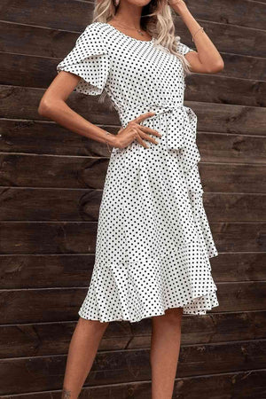 a woman wearing a white polka dot dress
