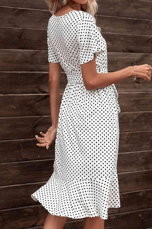 a woman wearing a white polka dot dress