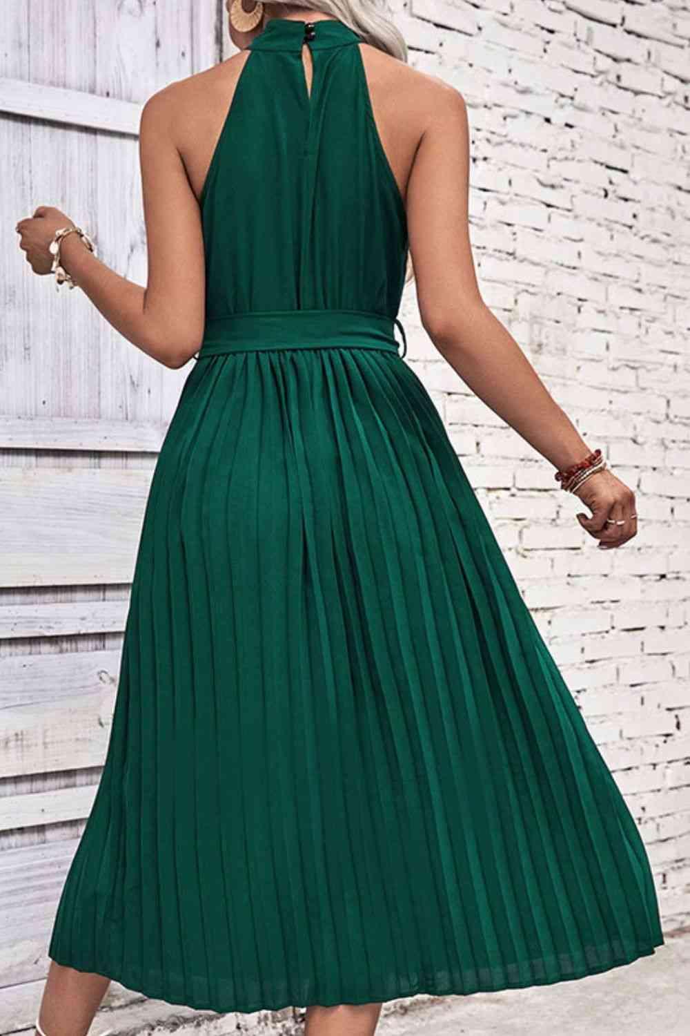 a woman wearing a green dress and heels