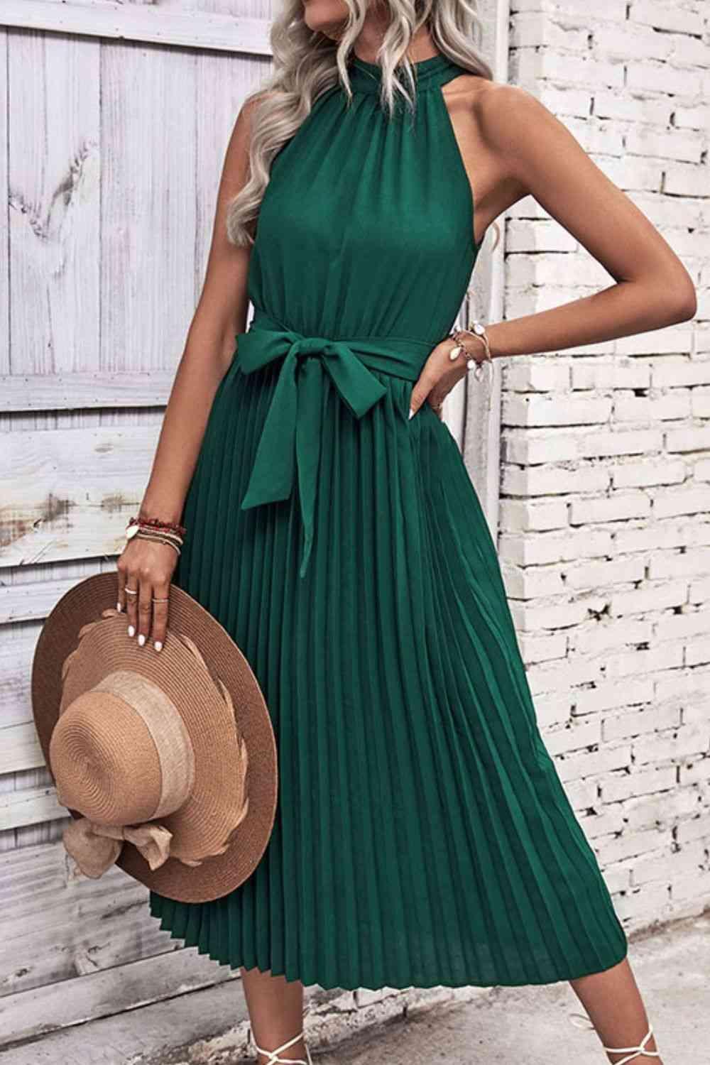 a woman wearing a green dress and hat