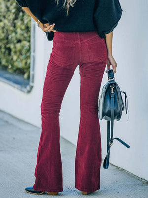 a woman in a black top and red pants