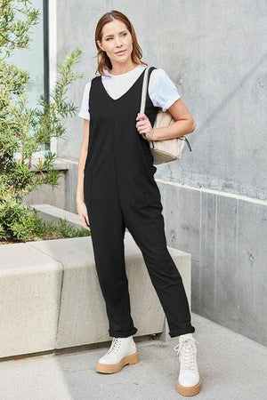 a woman in a black jumpsuit is posing for a picture