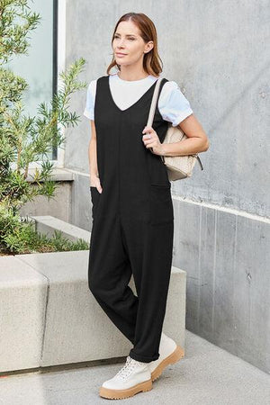 a woman in a black jumpsuit is posing for a picture