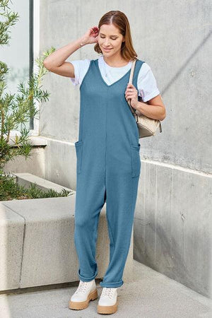 a woman in a blue jumpsuit and white shirt
