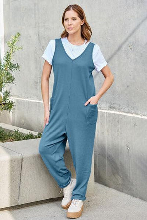 a woman in a blue jumpsuit posing for a picture