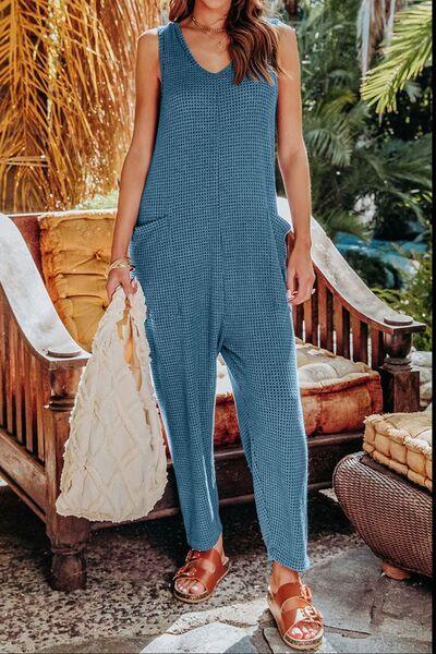 a woman in a blue jumpsuit holding a white bag