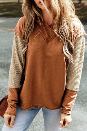a woman wearing a brown sweater and jeans