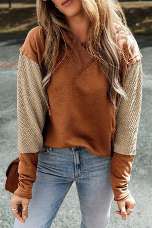 a woman wearing a brown sweater and jeans