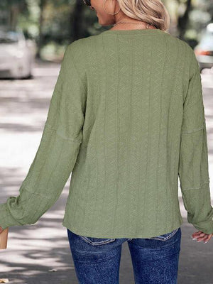 a woman wearing a green sweater and jeans