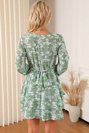 a woman wearing a green floral print dress