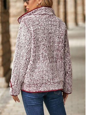 a woman standing on a sidewalk wearing a jacket