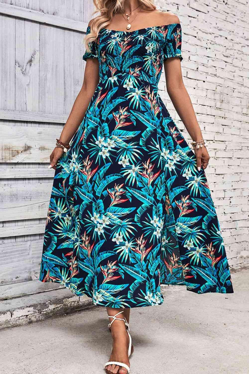 a woman wearing a blue tropical print dress