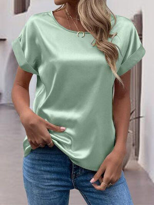 a woman wearing a green top and jeans