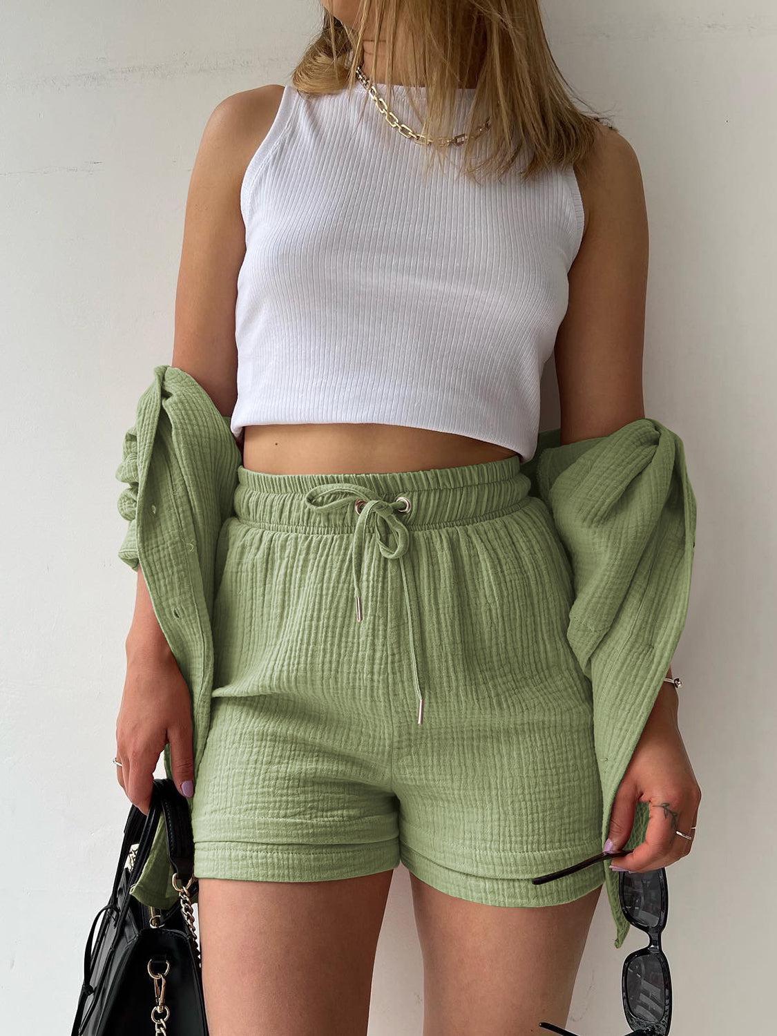 a woman wearing green shorts and a white top