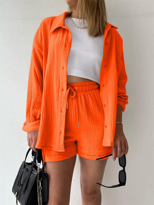 a woman wearing an orange jacket and shorts
