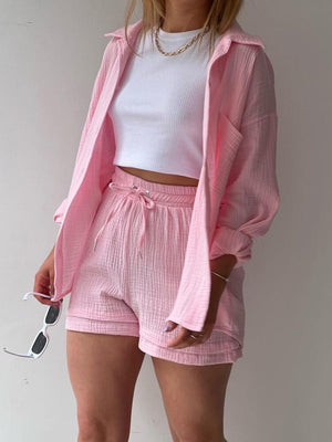 a woman wearing pink shorts and a pink jacket