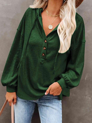 a woman wearing a green blouse and jeans