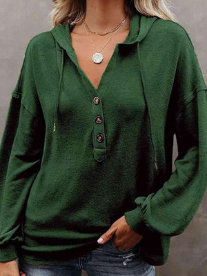 a woman wearing a green sweater and jeans