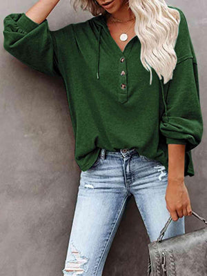 a woman wearing a green shirt and ripped jeans