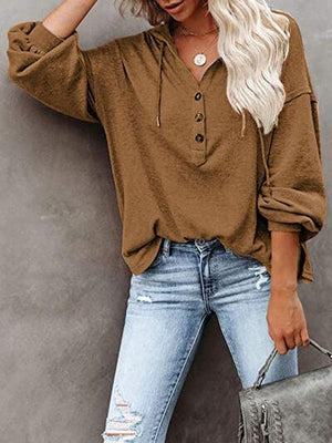 a woman wearing a brown shirt and ripped jeans