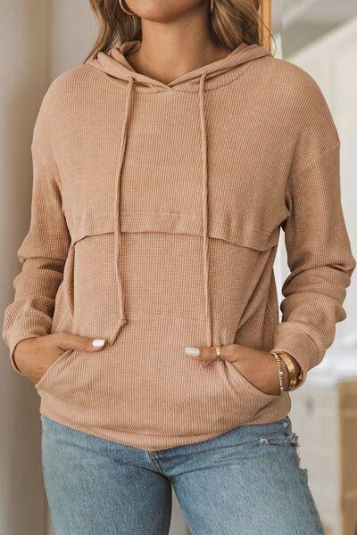 a woman wearing a brown sweater and jeans