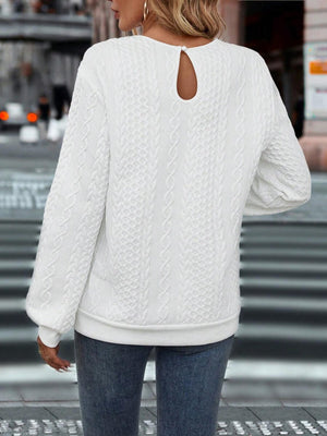 a woman wearing a white sweater and jeans