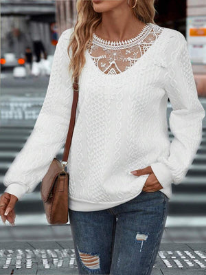a woman wearing a white sweater and ripped jeans