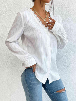 a woman wearing a white blouse and ripped jeans