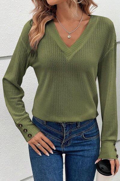 a woman wearing a green sweater and jeans