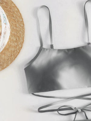 a bikini top and a straw hat on a white surface