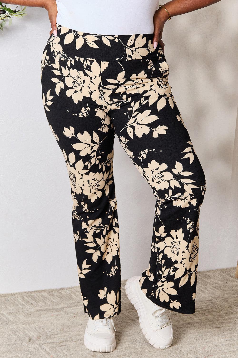 a woman in white shirt and black floral pants