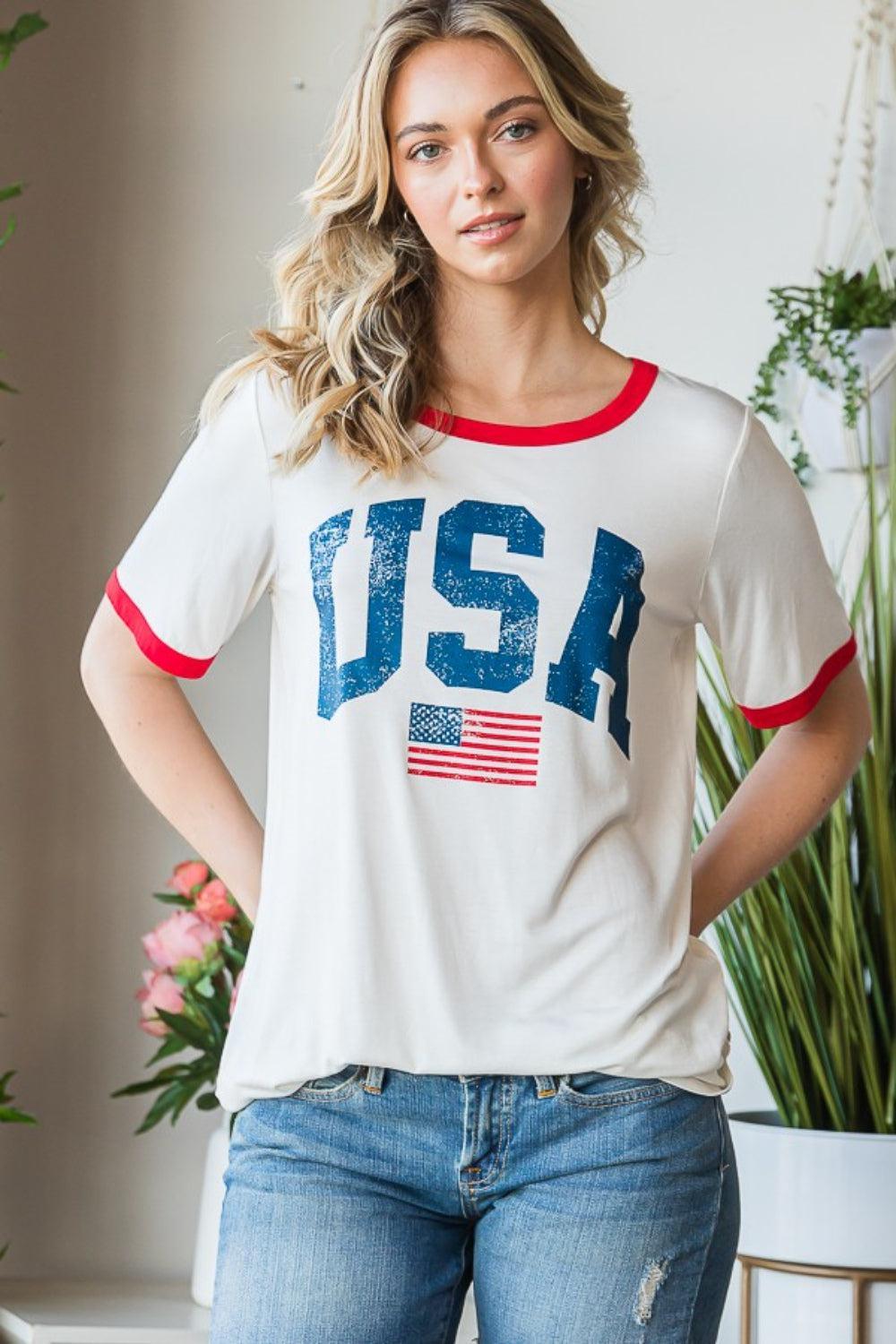 a woman wearing a usa t - shirt standing in front of a potted plant