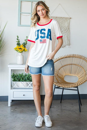 a woman standing in front of a chair wearing a usa t - shirt