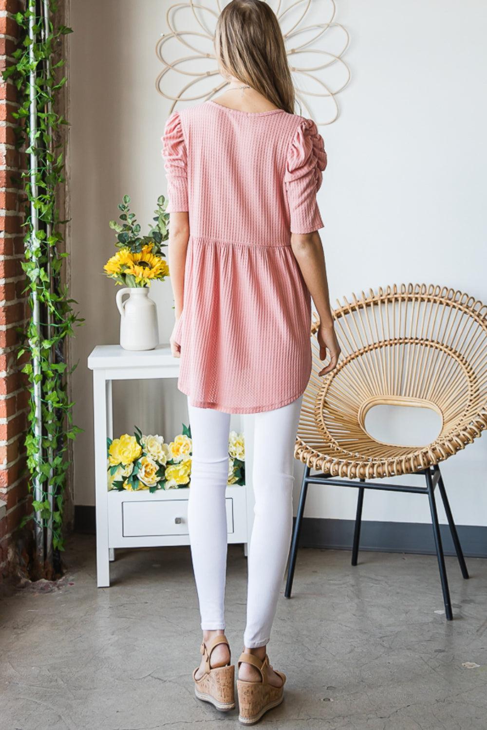 a woman standing in front of a wicker chair