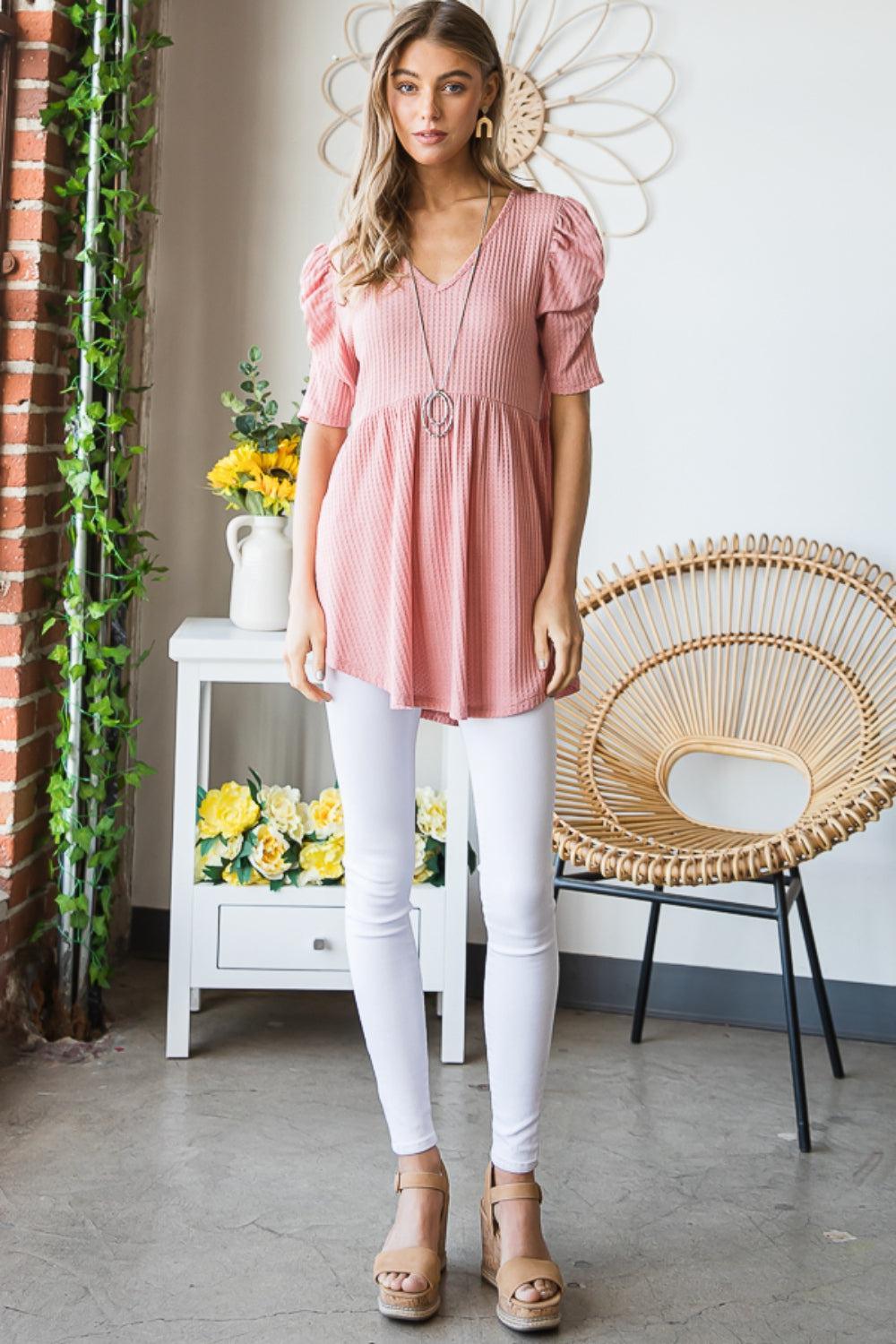 a woman wearing a pink top and white pants