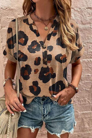 a woman wearing a leopard print shirt and denim shorts