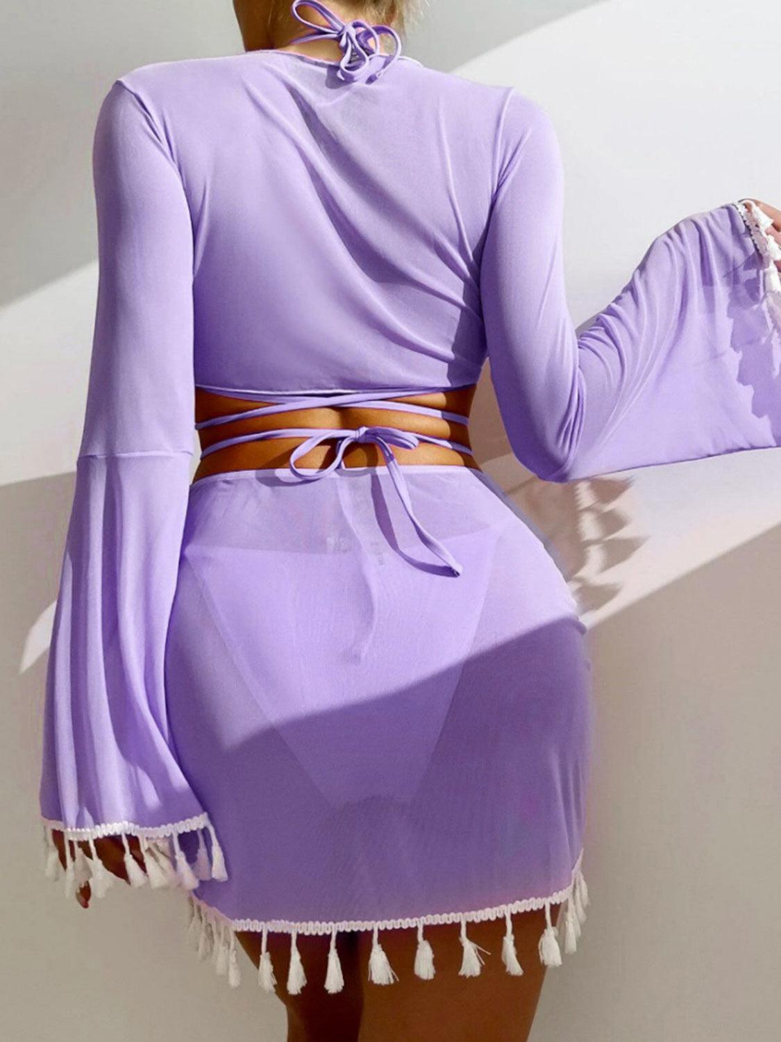 a woman wearing a purple dress with a tassel around the waist