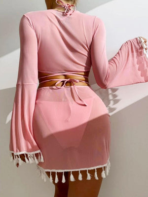 a woman wearing a pink dress with a tassel around the waist