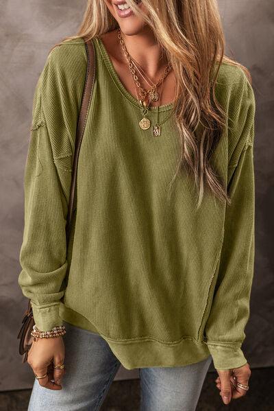 a woman wearing a green sweater and jeans