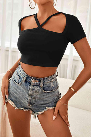 a woman wearing a black top and denim shorts