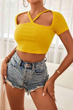 a woman wearing a yellow top and denim shorts