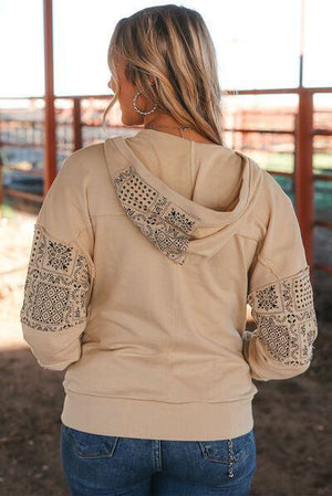 a woman wearing a tan jacket and jeans